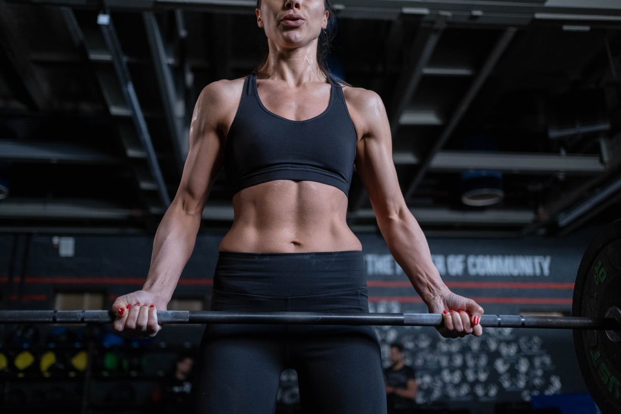 Woman in Black Sportswear Lifting a Barbell