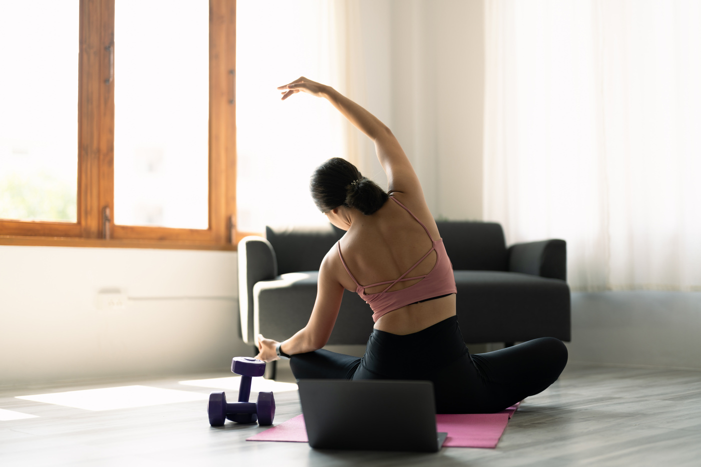 Young attractive woman practicing yoga in online yoga class